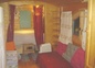 a roulotte de Shanti, couchage lit banquette à droite et alcôve avec lit 160 au fond